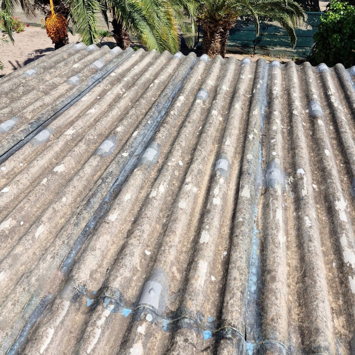 Rusty corrugated rubber roof with visible signs of aging and weathering.