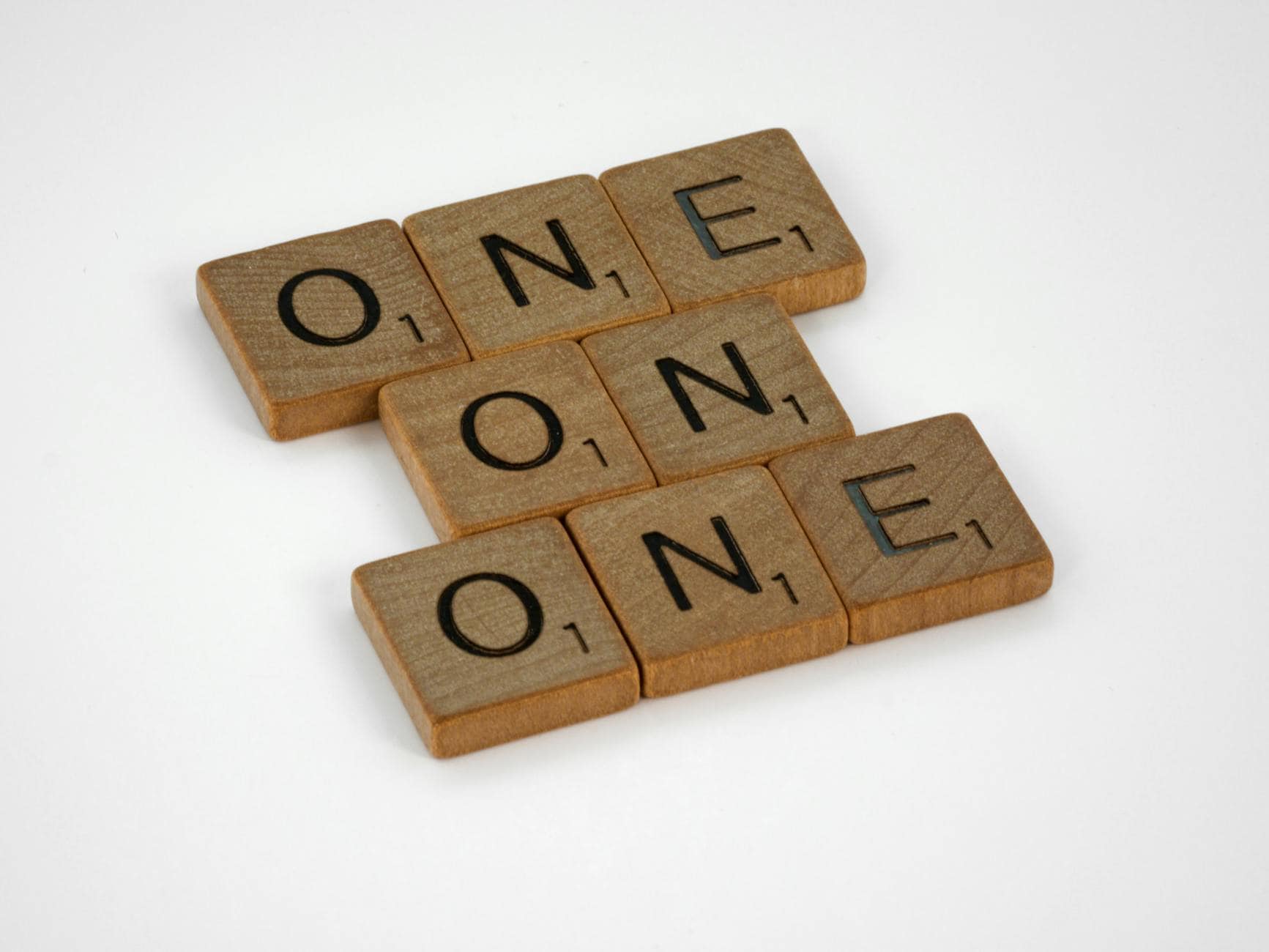 Wooden blocks spelling "ONE" symbolizing unity and faith in mental health coaching.
