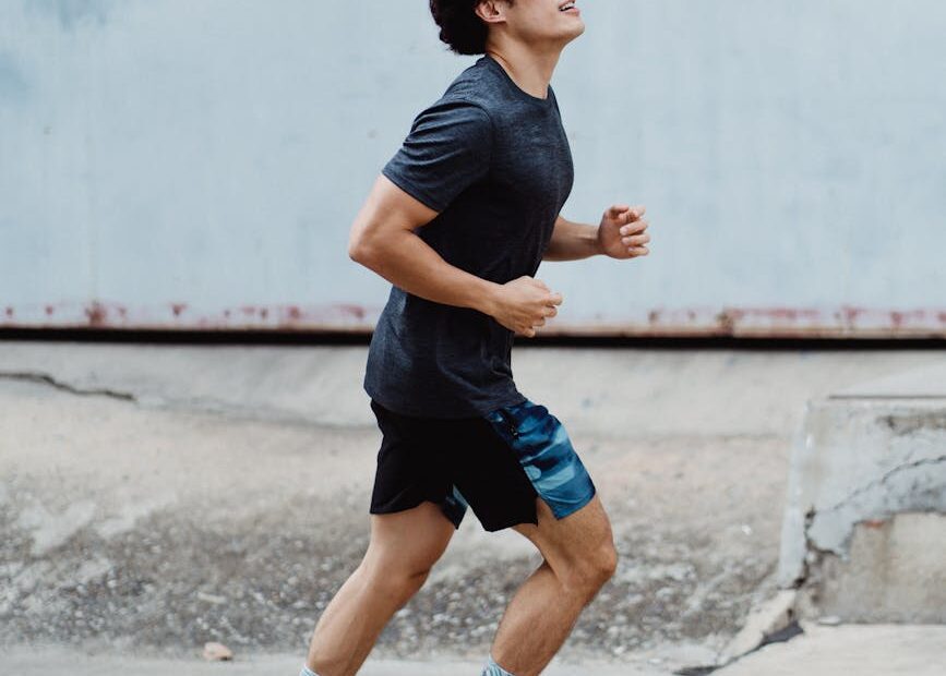 Man running outdoors to improve running habits and build consistency.
