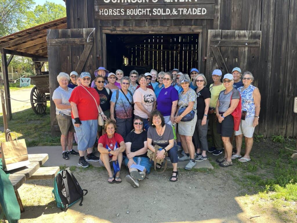 Group of RV travelers gathered outside a rustic barn at Angels Camp RV Resort during the April 2026 event, showcasing community and outdoor adventure.