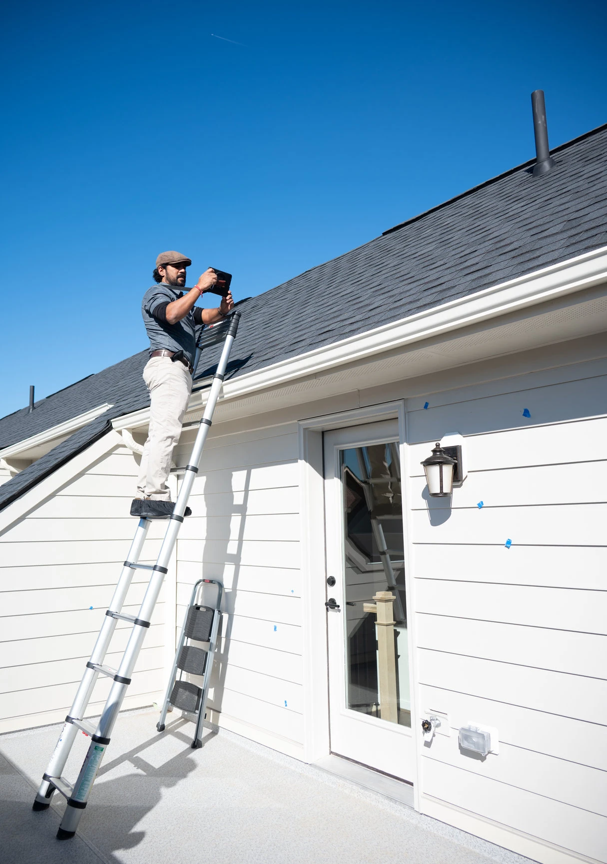 Inspector inspection roof conditions on a step-ladder