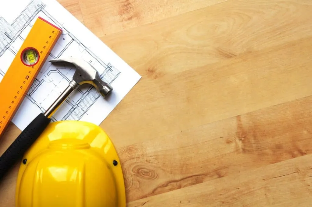Construction hat and tools on wooden table
