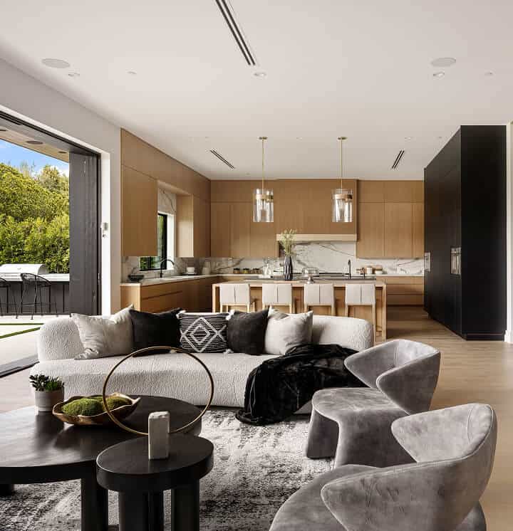 Luxury modern living room with sleek kitchen, stylish furniture, and natural light.