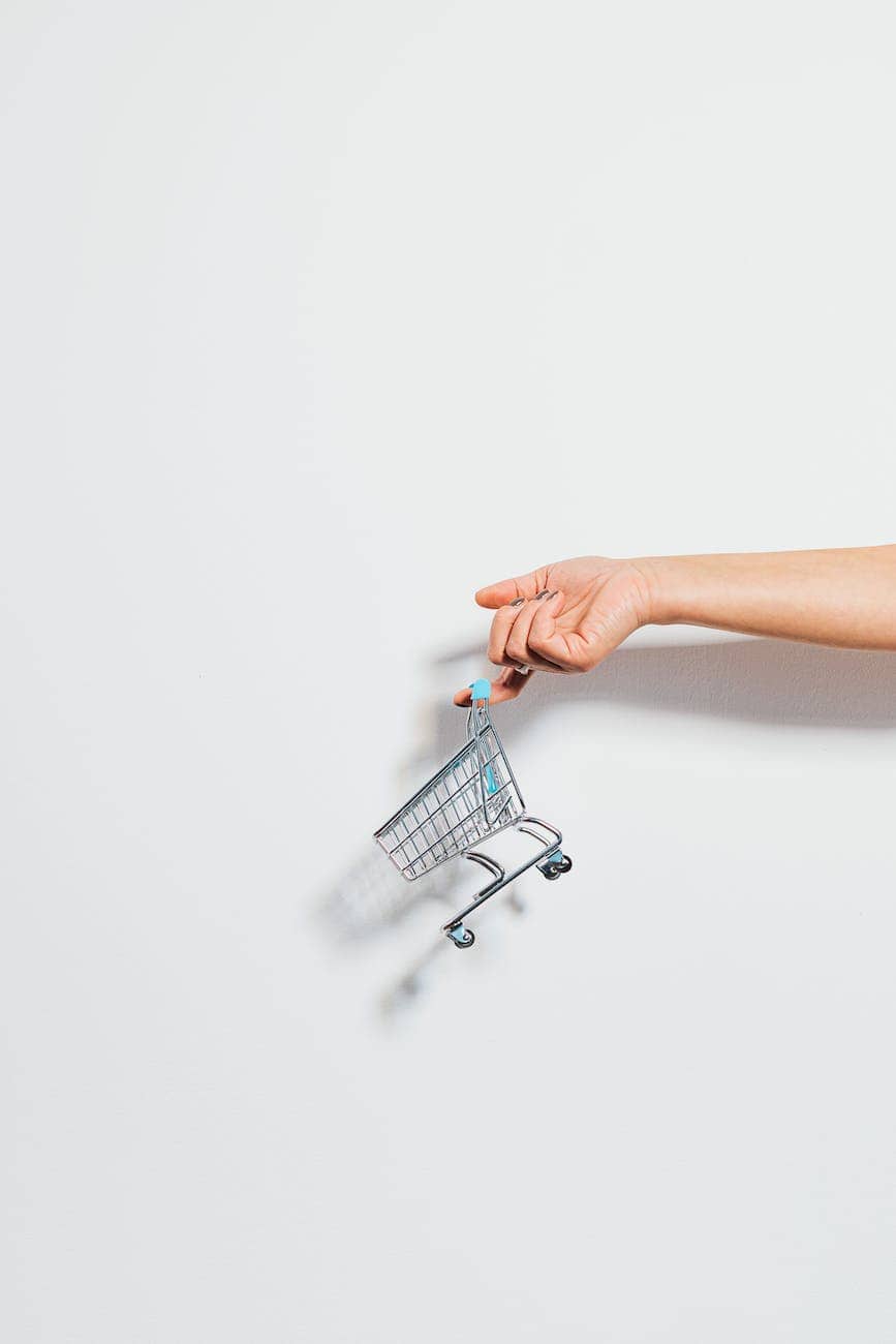 tiny shopping cart hanging on a finger