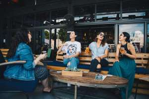 four women chatting while sitting on bench seeking advice