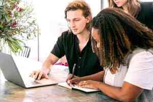 man working on laptop while woman takes notes top 10 startups 2023