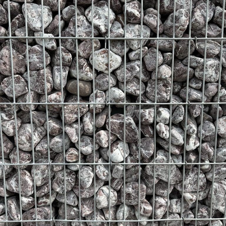 Kruszywo kamienne w metalowym ogrodzeniu, idealne do budowy i wykończeń.