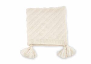 Mjuk handvävd filt med pompomdekoration i naturlig ull för mysig stil.