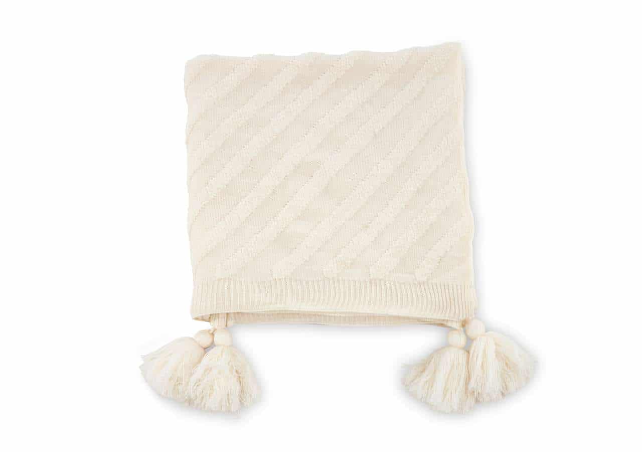 Mjuk handvävd filt med pompomdekoration i naturlig ull för mysig stil.