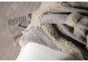 Mjuk pläd i ullmix med ullärmar, perfekt för mysiga stunder.