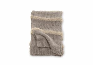 Mjukt ullpläd i beige med randmönster och fransar för mysiga sovrumsmiljöer.