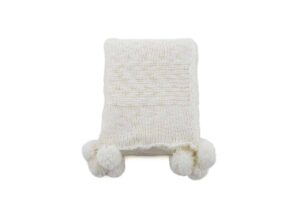 Ljus eller vit stickad pläd med pom-pom-uttalanden för mysig sängkomfort.
