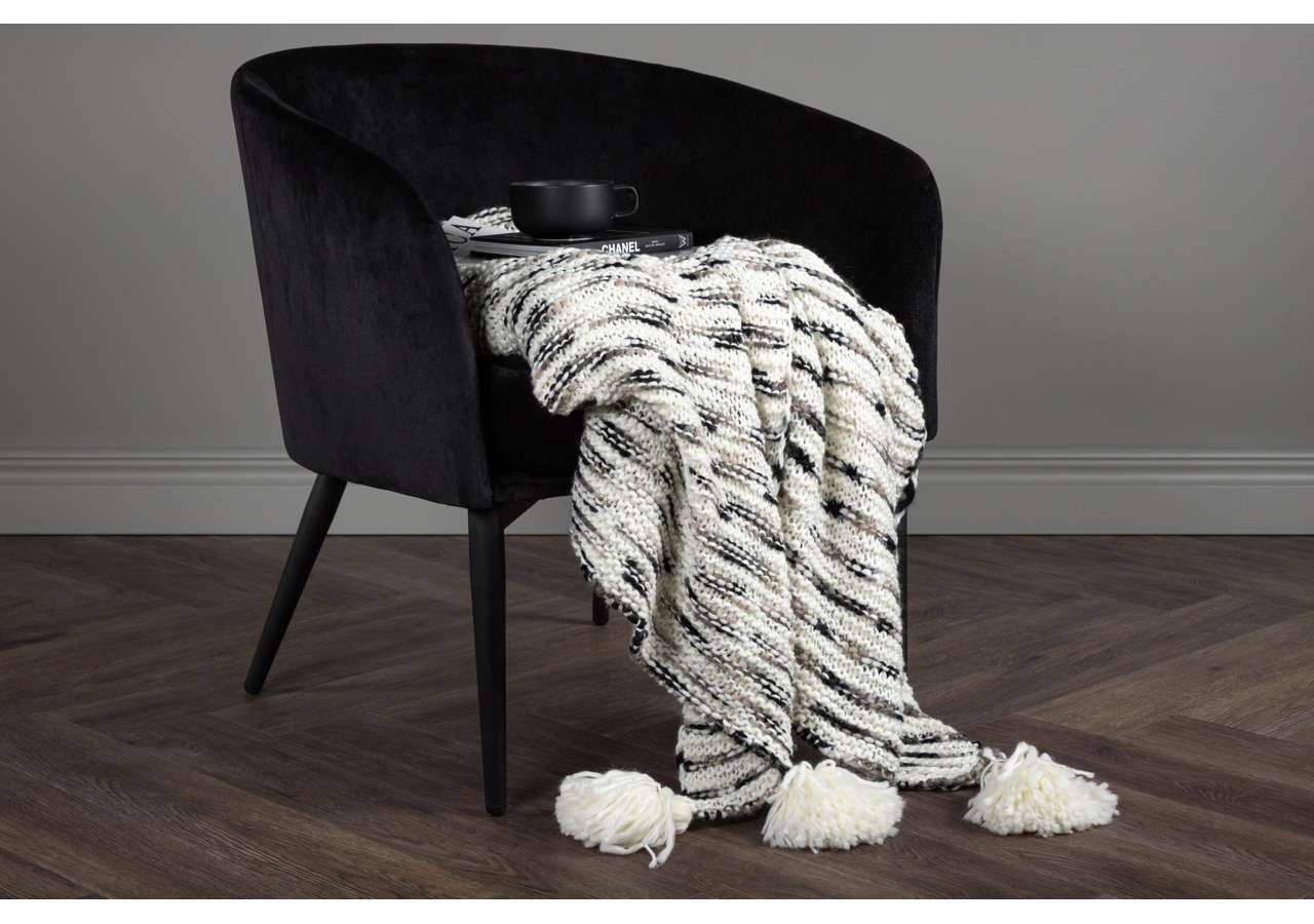 Mörk tylsoffa med vävd filt och bokstöd, elegant samt samlingsplats för avkoppling.