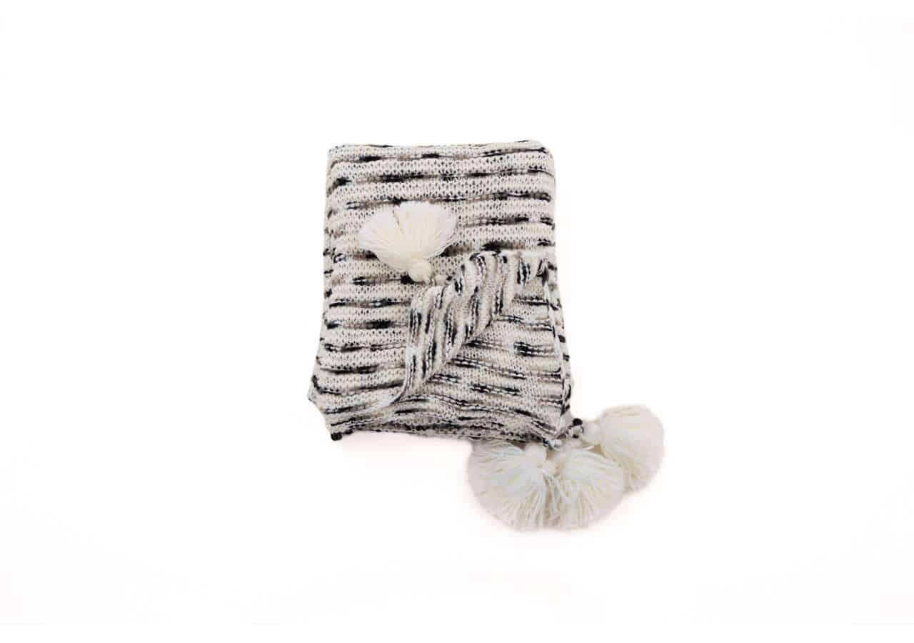 Ljus och stilren filt i svartvitt med tofsar för mys och komfort.