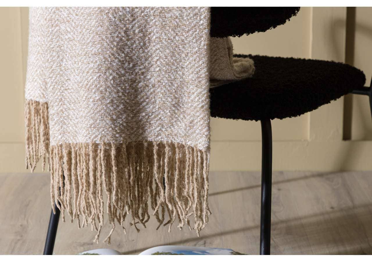 Mönstrad beige och svart pläd på svart stol, sängfabriken, högkvalitativa sängkläder.