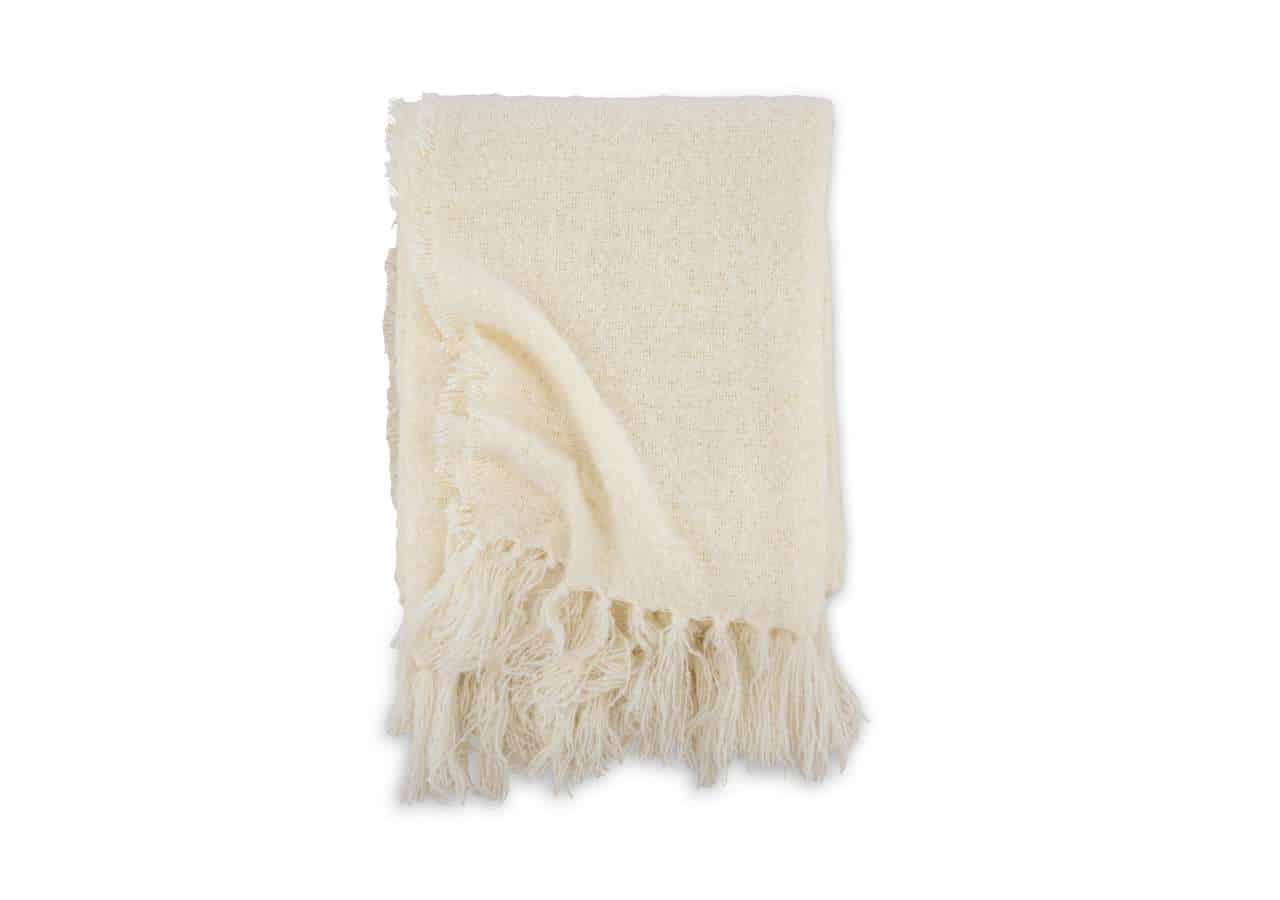 Linnefilt i ull med fransar, lyxig och mjuk, perfekt för sovrummet.