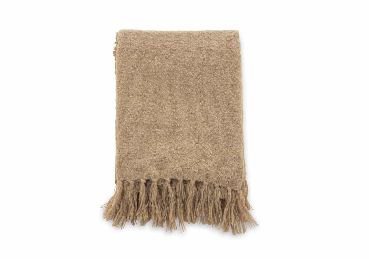 Mysig beige ullfilt med fransar, perfekt för sängkläder eller heminredning.