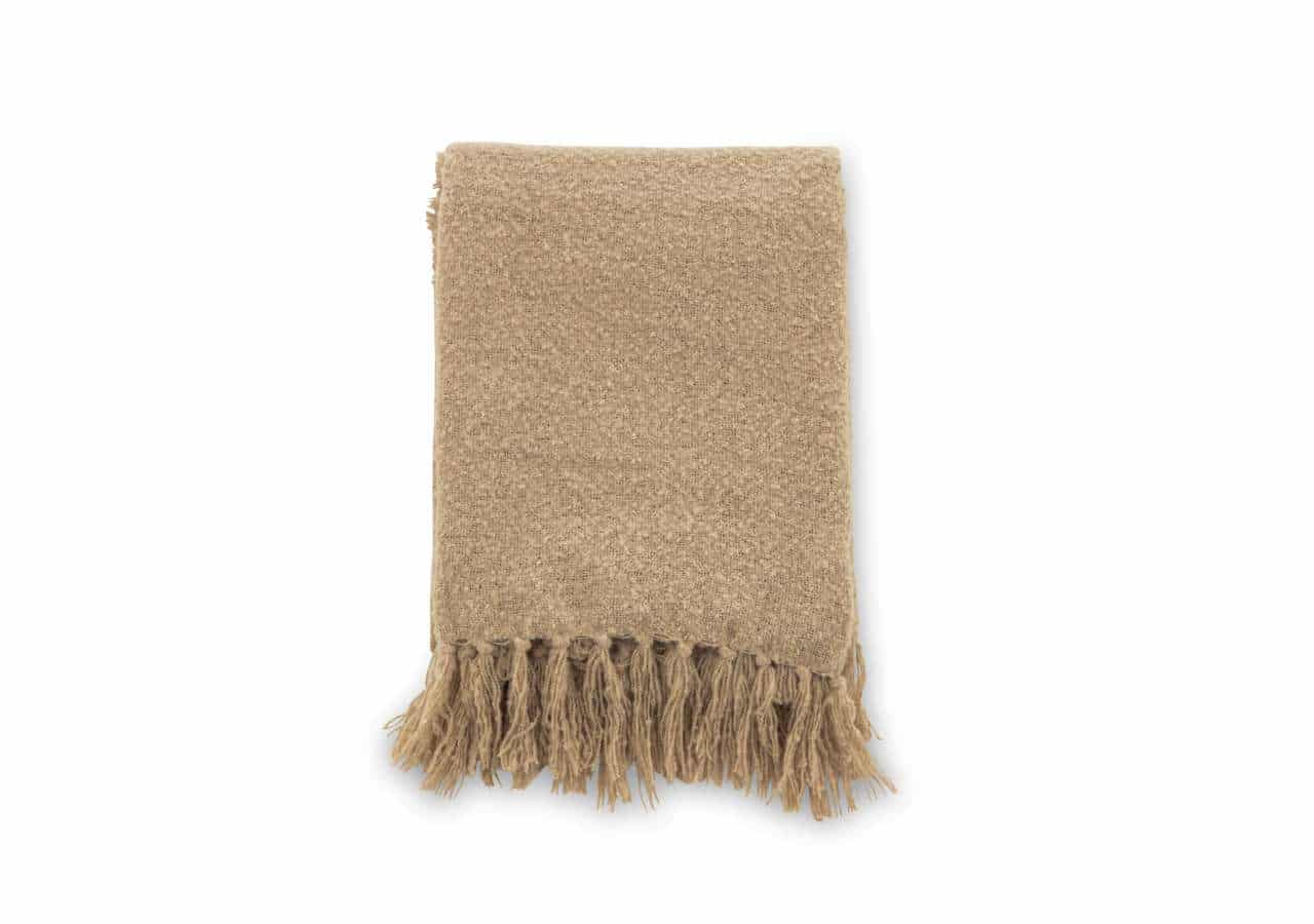 Lätt beigefärgad handvårdad filt med fransar, perfekt för mys och komfort.