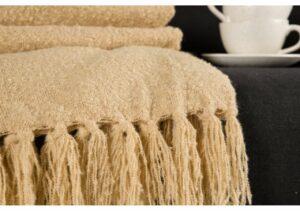 Mjuk beige frottéhandduk med fransar, perfekt för badrum och hotell.