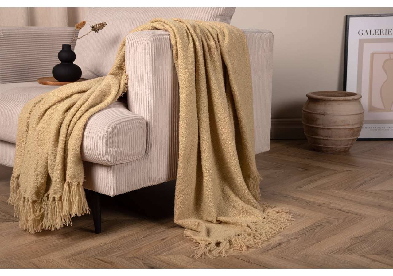 Mjuk, beige pläd över soffan i modern inredning - Sängfabriken Stockholm.