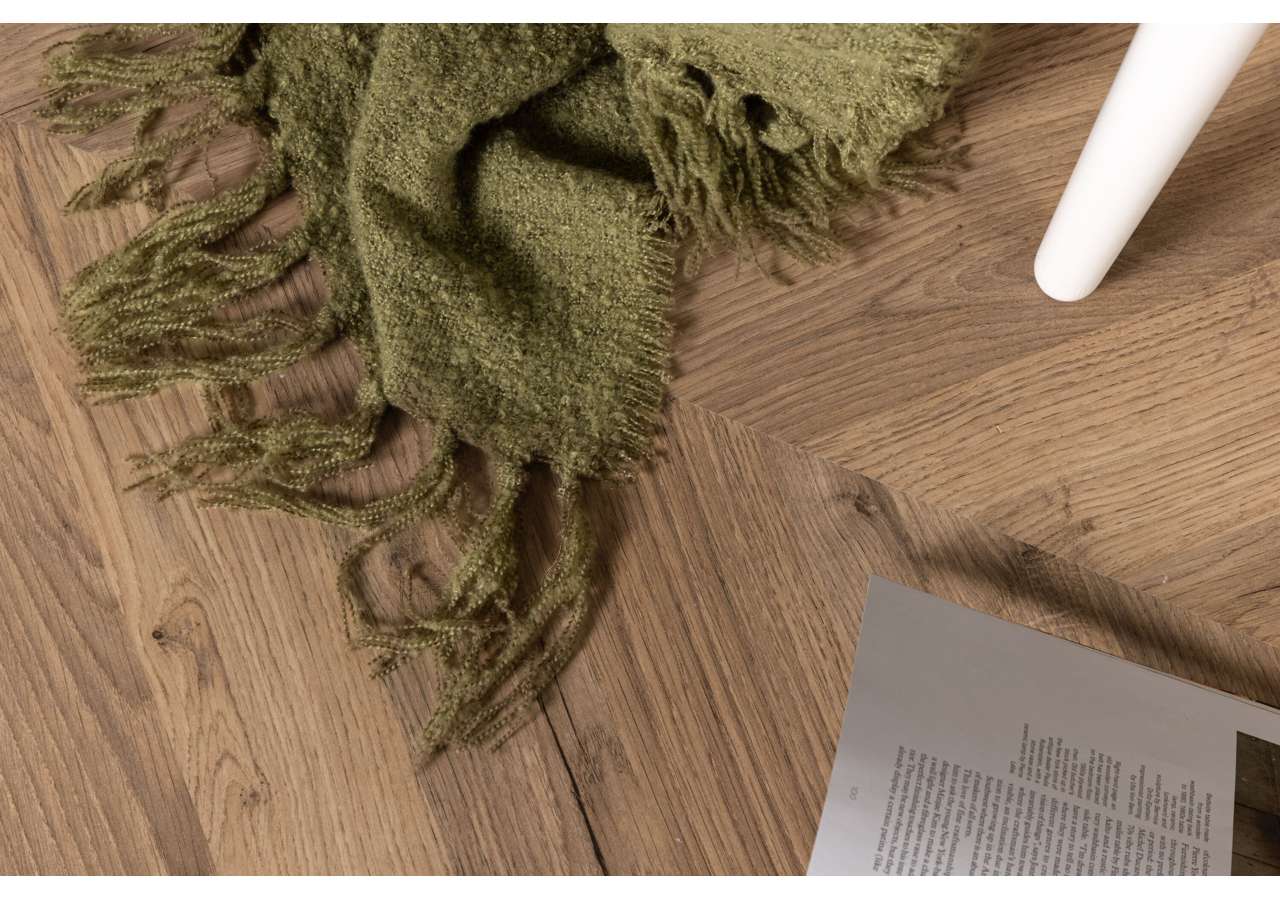 Mjuka, gröna handvävda plädar på trägolv för skandinavisk inredning.