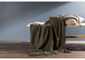 Mörk grön pläd på sovbänk, mysig inredningsdetalj för alle tänkbara sovrum.