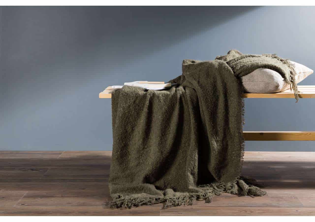 Mörk grön pläd på sovbänk, mysig inredningsdetalj för alle tänkbara sovrum.