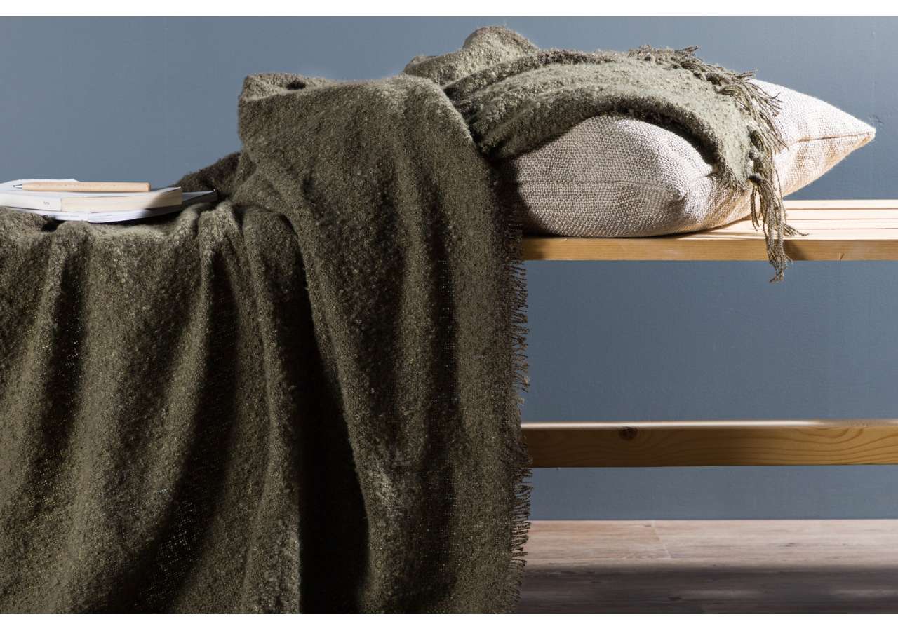 Mysig sovplats med filtar och kuddar i skandinavisk stil.