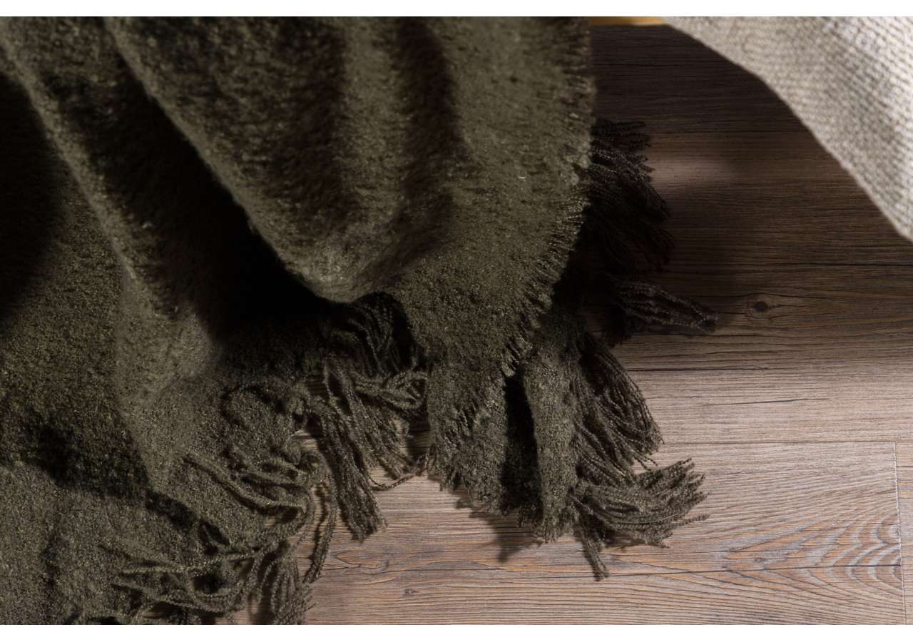 Mjukt, frottévävt, grått täcke med fransar, perfekt för sovrum eller loungemiljö.