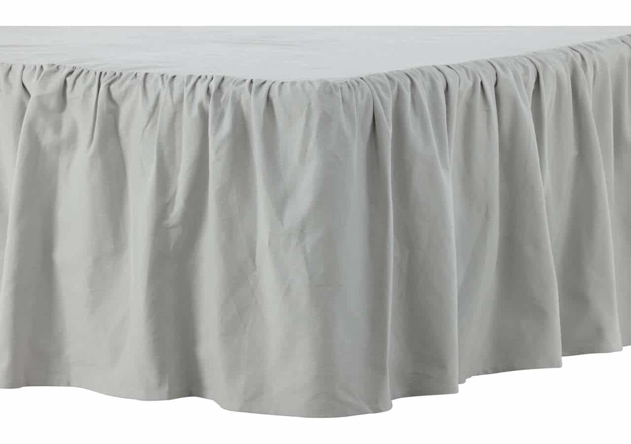 Lång, vit sänggavel med elegant veckad gardinstil design för sovrum.