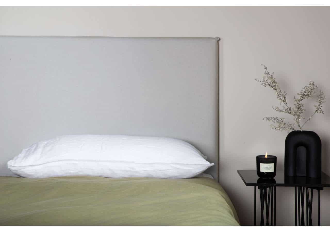 Säng med vit kudde på stilrent sovrum, minimalistisk heminredning.