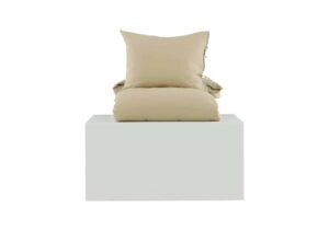 Madrasskydd och prydnadskudde i beige på vit bakgrund, sängfabriken stil.