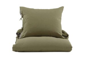 Ljust grön sängkudde och överkast, stilren sovrumsinredning.