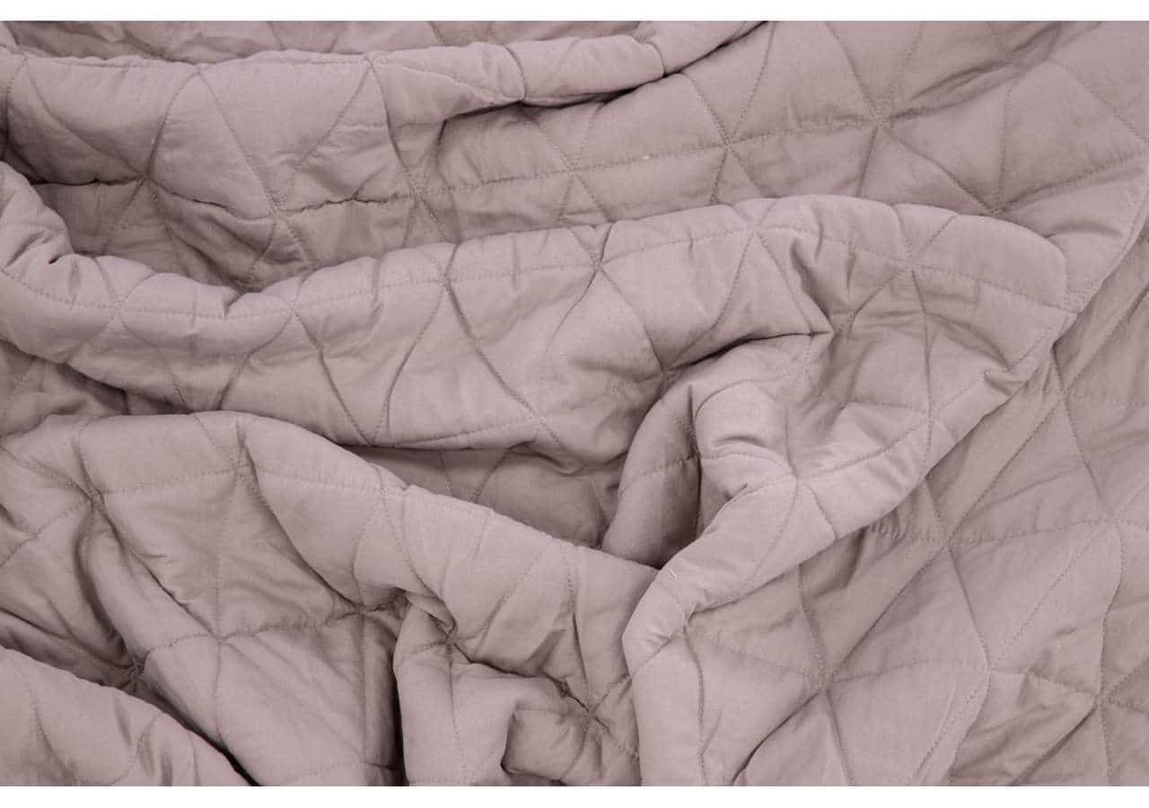 Mjukt bäddset i beige med quiltad design för komfort och elegans.