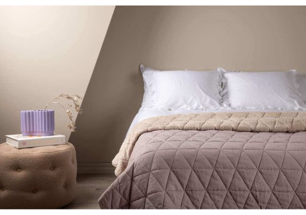 Mysig säng med romantiska sängkläder och nattduksbord i modern svensk inredning.