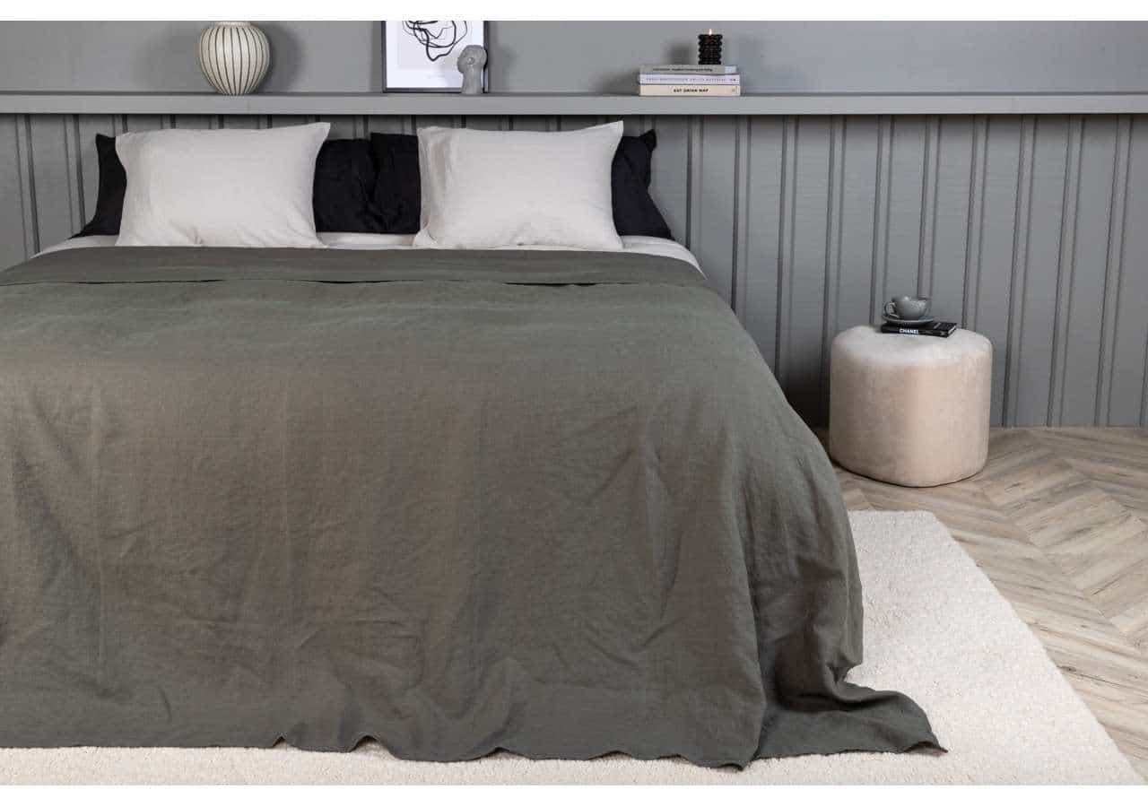 Bekväm säng med stilrent grått och svart bäddset i modern sovrumsdesign.