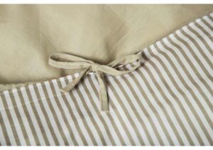 Lakan med randig mönster och knytband i beiget ton.