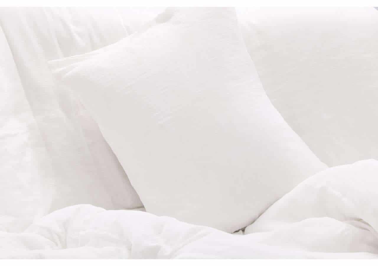 Mjukt vitt sängkläder och kuddar för en bekväm sömn.