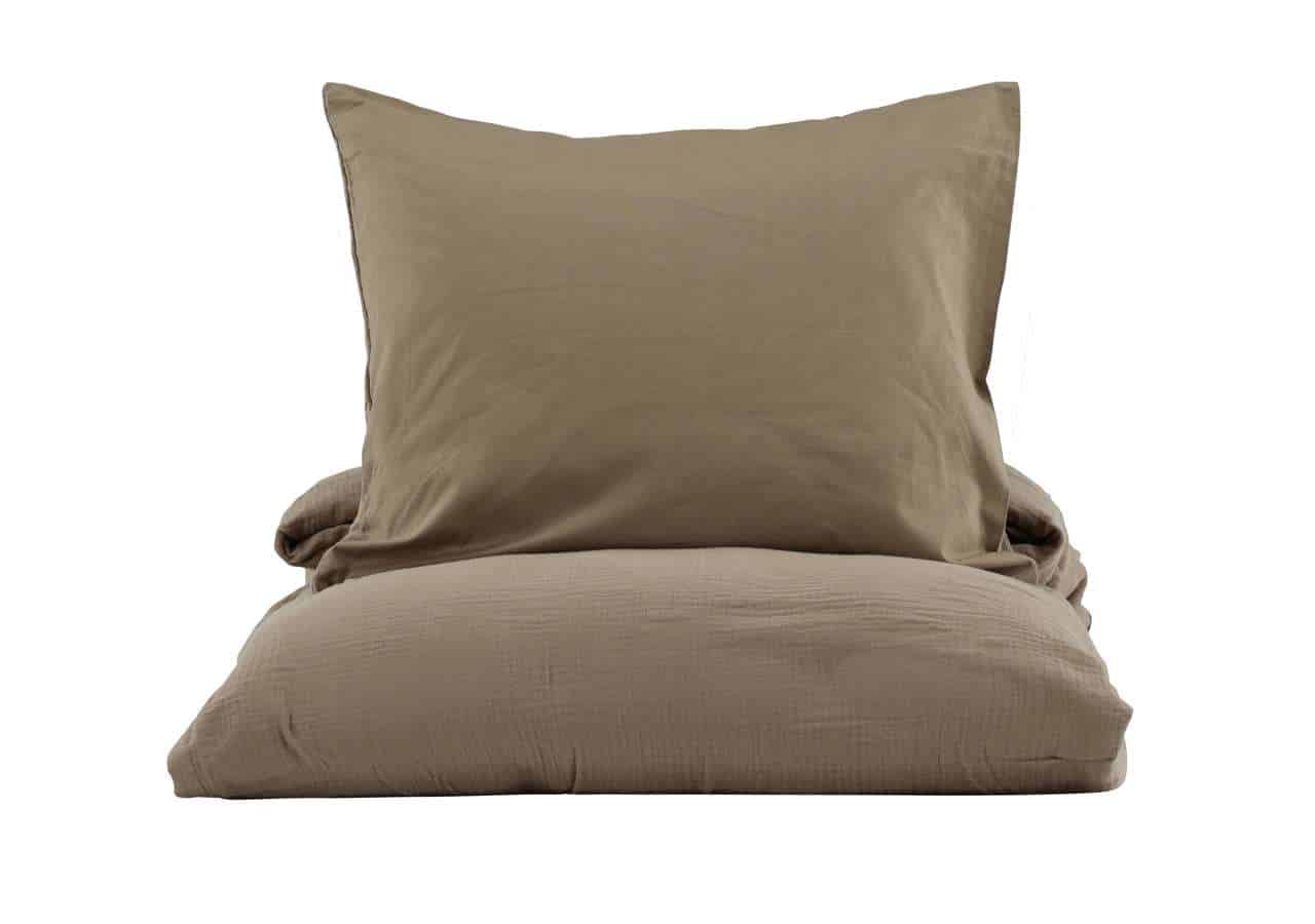 1. Sängkläder i svalt beige med bekvämt överkast och örngott.