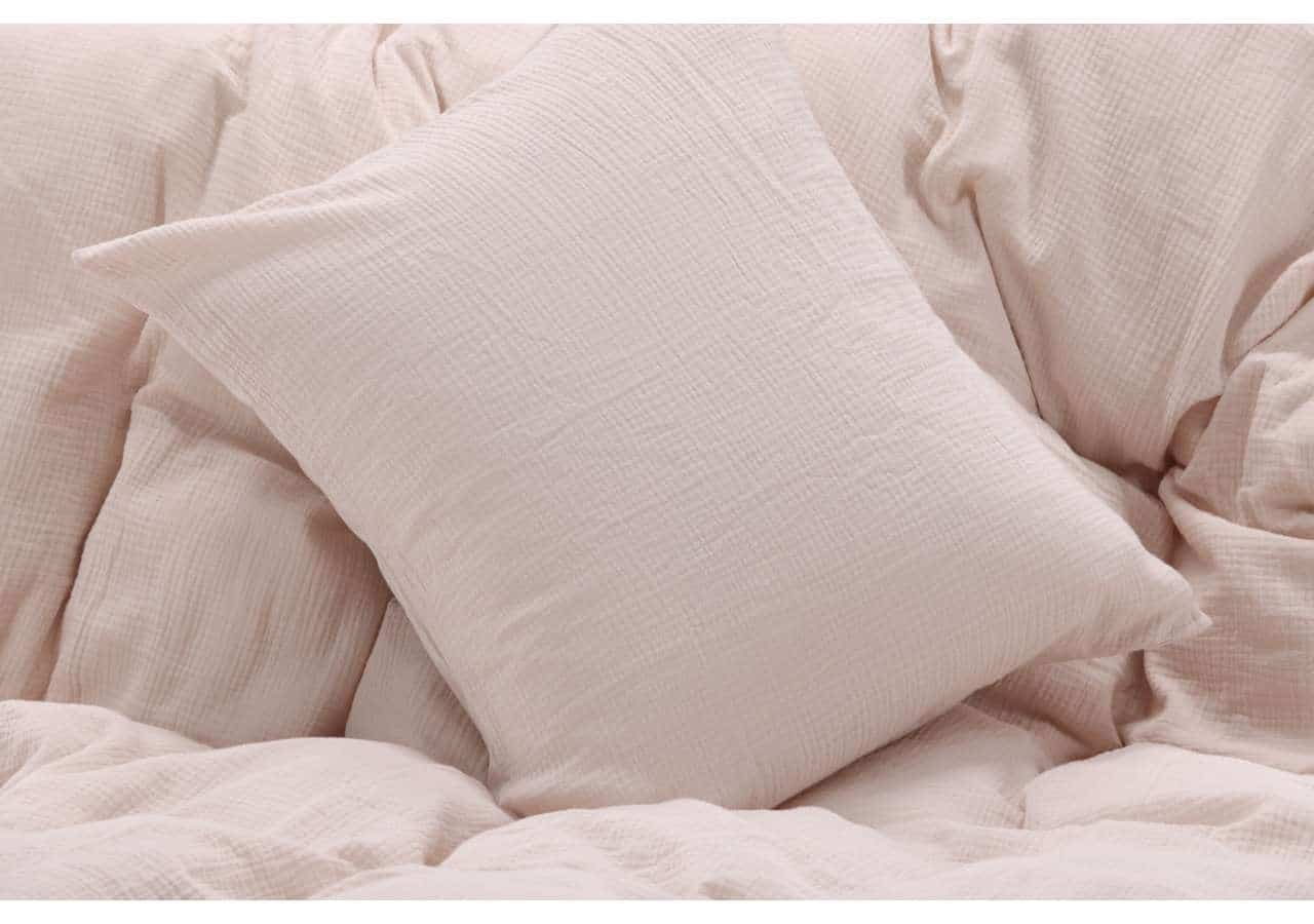 Mjuk och tunn sängkudde i puderrosa tyg för skön sömn och avkoppling.