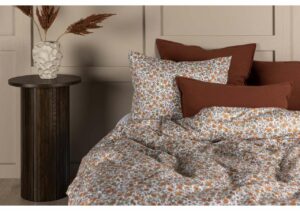 Mjukt sängklädesset med blommönster och rödbruna kuddar, för sköna sovnätter, från Sängfabriken.
