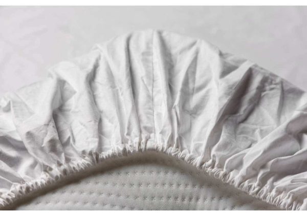 Lakanpassning för sängar av hög kvalitet med mjuk, vitt bomullstyg.