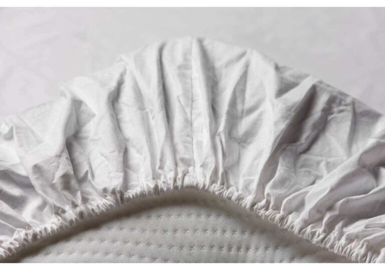 Lakanpassning för sängar av hög kvalitet med mjuk, vitt bomullstyg.