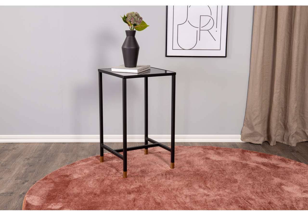 Konsolbord i svart metall med dekorativ vas och konsttryck, perfekt för sovrum eller vardagsrum.