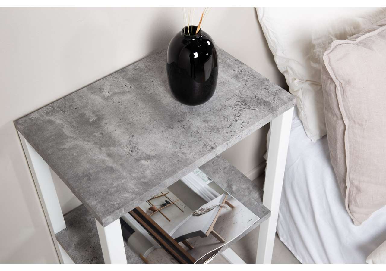 Modern sängbord med betongyta och vitt fundamentsram.
