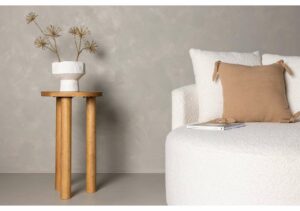 Vacker vit blomvas på träbord i minimalistisk sovrumsmiljö.