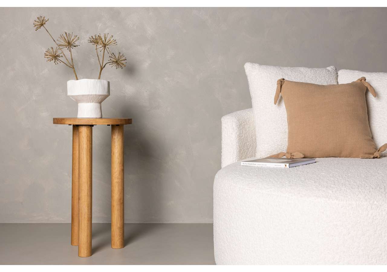 Vacker vit blomvas på träbord i minimalistisk sovrumsmiljö.