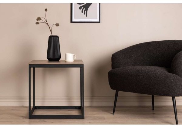 Modern svart lampa på sidebord i vardagsrum.