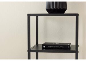 Modern svart sänggavel med dekorativ vacker vas på sängbord.