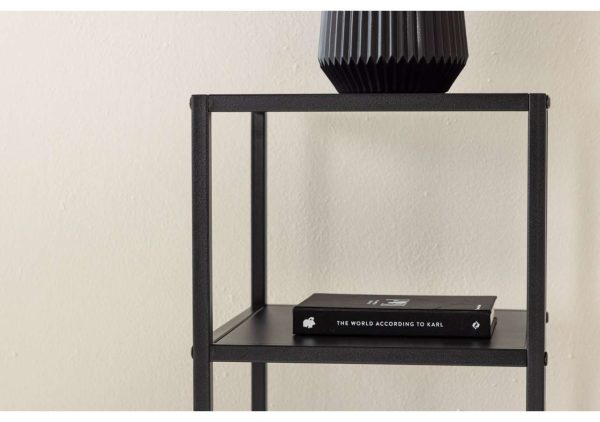 Modern svart sänggavel med dekorativ vacker vas på sängbord.